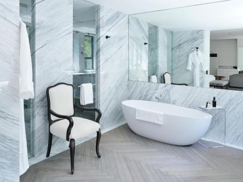 a bathroom with a tub and a chair and a mirror at Casa Polanco Hotel Boutique in Mexico City
