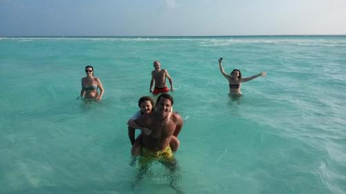a group of people in the water in the ocean at Rasdhoo Coralville in Rasdu