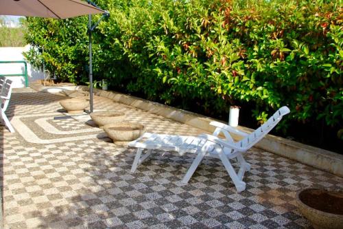 - un banc blanc et un parasol sur la terrasse dans l'établissement Villa Giovanna, à San Pietro in Bevagna