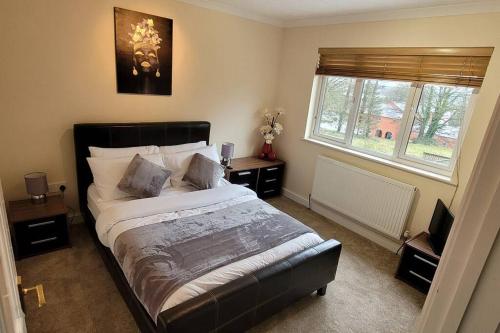 a bedroom with a large bed and a window at Tides Reach - 3 Bedroom Holiday Home - Llanreath in Pembrokeshire