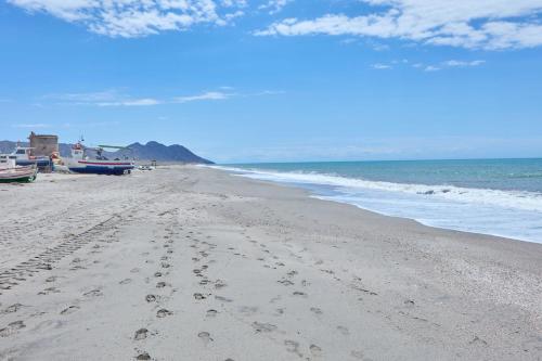 a beach with footprints in the sand and the ocean at Apartamento Luna Cabo de Gata in El Cabo de Gata