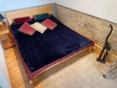 a bed with three pillows on top of it at Nationalpark Lobau Wohnung in Groß-Enzersdorf