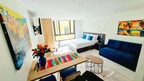 un salon avec un canapé bleu et un canapé bleu dans l'établissement Toscana LOFT - Apartasuites, à Bogotá