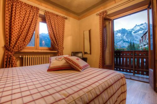 a bedroom with a bed and a large window at B&B Residence Checrouit in Courmayeur