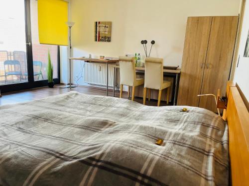 1 dormitorio con 1 cama, mesa y sillas en Schönes Apartment in perfekter Lage, en Mönchengladbach