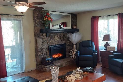 a living room with a stone fireplace in a living room at J.Creek Retreat, creekside townhouse +1 car garage in Maggie Valley