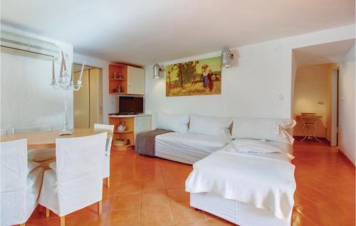 een slaapkamer met een bed en een tafel en stoelen bij Cozy Apartment In Mali Losinj With Kitchen in Mali Lošinj