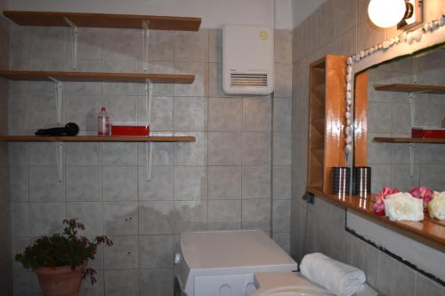 a bathroom with a toilet and a sink and shelves at PIGADIA in Vromonérion