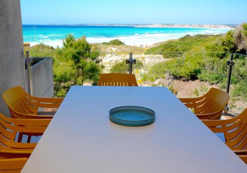 a table with a plate on it with a view of the beach at Apartments Es Trenc in Ses Covetes