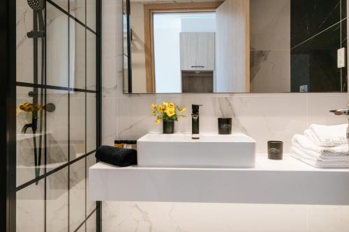a bathroom with a white sink and a mirror at At Herbal Boutique Hotel & Spa in Protaras
