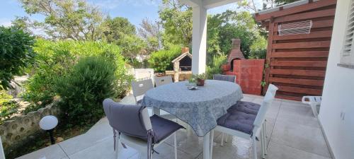 a patio with a table and chairs on a patio at Apartment Tonci in Novalja