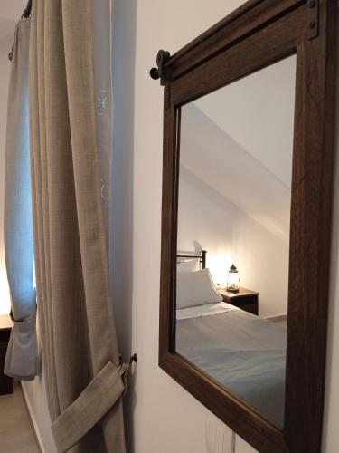 a mirror on a wall next to a bed at Stilvi Milos in Plaka Milou