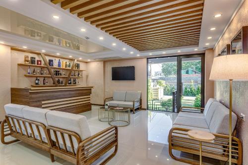 a lobby with a waiting room with chairs and a tv at Vinum Hotel in Tbilisi City