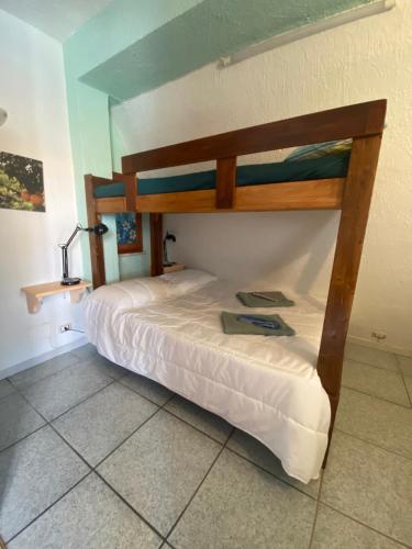 Letto a castello in legno in camera con pavimento piastrellato di Sea View 2 Bedroom Vacation Apartment a Giardini Naxos
