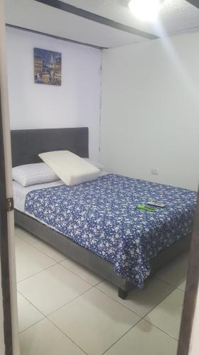 1 dormitorio con 1 cama con sábanas azules y blancas en cerca aeropuerto embajada EEUU fotos huellas visa, en Bogotá