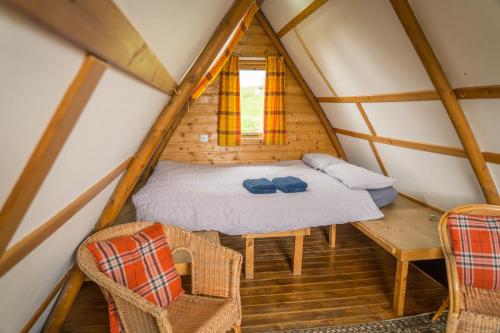 a room with a bed and a table and chairs at Shepherd's Loch Glamping in Turriff