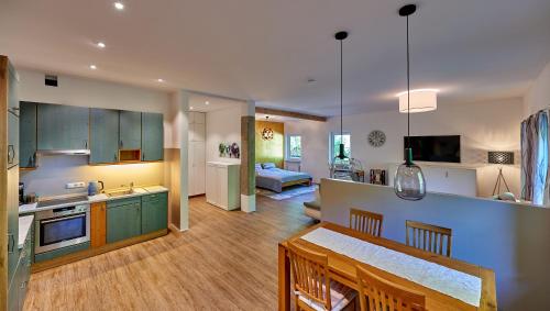 eine Küche und ein Wohnzimmer mit grünen Schränken in der Unterkunft Ferienwohnung Sicado Loft in Aschau im Chiemgau