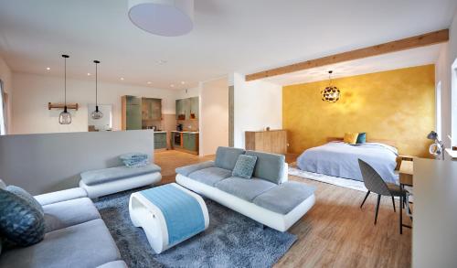 duży salon z łóżkiem i kanapą w obiekcie Ferienwohnung Sicado Loft w mieście Aschau im Chiemgau