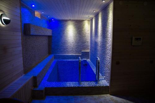 a bathroom with a tub with blue lights in it at Autopapa in Rustavi