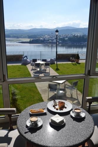 a table with food on it with a view of the water at Parador de Ribadeo in Ribadeo