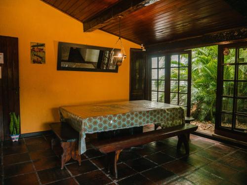 ein Zimmer mit einem Tisch und einer Bank darin in der Unterkunft Numa Boa HOSTEL Búzios in Búzios