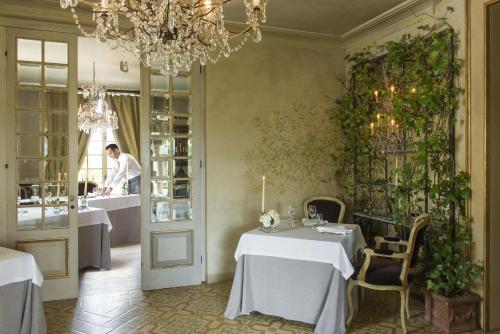 a restaurant with two tables and a man in the kitchen at Borgo Santo Pietro in Chiusdino