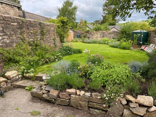 a garden with a stone wall and flowers at Six on Castle in Tiverton