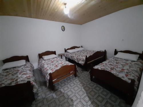 um quarto com três camas num quarto em Guest House Emanueli em Tropojë