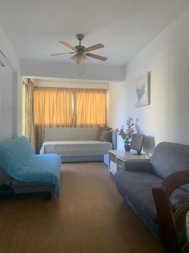 a living room with a couch and a ceiling fan at Green Nondas Hill in Larnaka