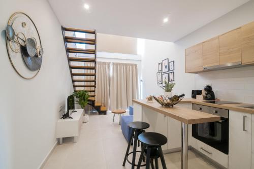 eine Küche mit einer Theke und Hockern in einem Zimmer in der Unterkunft Stylish & elegant loft suite in the city center in Zakynthos