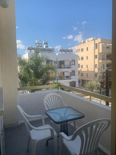 una mesa y sillas en un balcón con vistas en Green Nondas Hill, en Lárnaca
