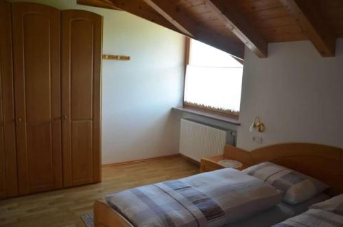 a bedroom with a large bed and a window at Bühel im Gschleier in Appiano sulla Strada del Vino