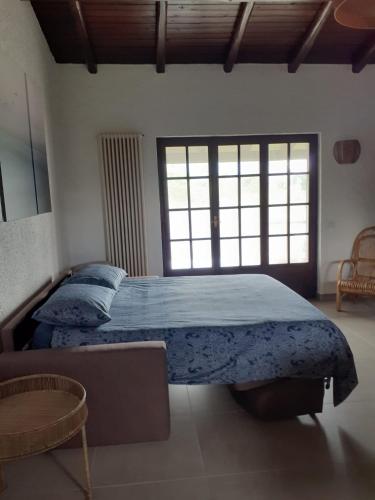 a bedroom with a bed with a blue comforter at Feluca Porto in Porto Valtravaglia