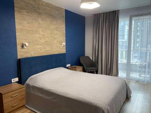 ein Schlafzimmer mit einem Bett, einem Stuhl und einem Fenster in der Unterkunft Resident Hall in Lwiw