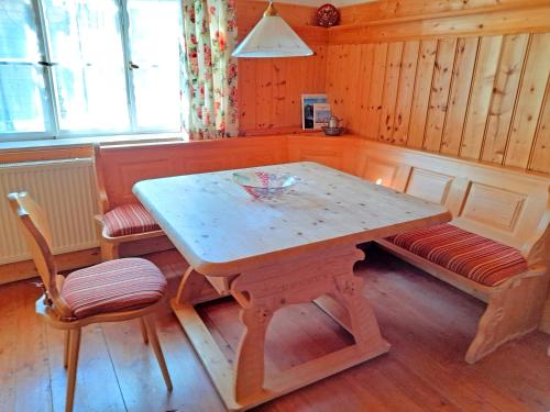 uma mesa de madeira e duas cadeiras num quarto em Ferienwohnung Spitzsteinblick em Sachrang