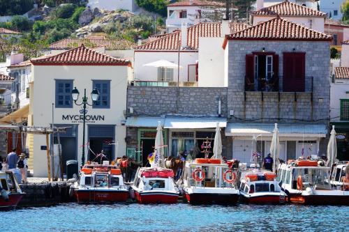 a group of boats docked in a harbor with buildings at MyCrown Suite, Luxurious apartment with sea view located at the port of Hydra in Hydra