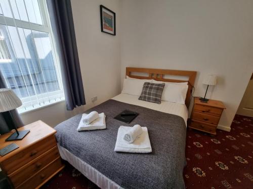 a bedroom with a bed with two towels on it at The Cameo in Blackpool