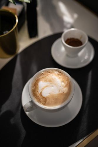 two cups of coffee sitting on a table at Relais Manzoni in Rome