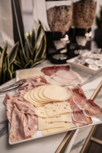 a plate of cheese and meats on a table at Relais Manzoni in Rome