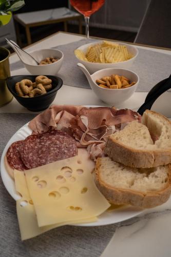 a plate of food with meat cheese bread and other foods at Relais Manzoni in Rome