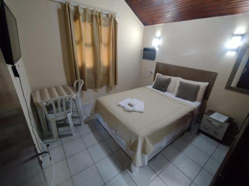 a small bedroom with a bed and a chair at Vale do Pontal Angra Suites in Angra dos Reis