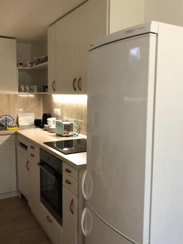 a white refrigerator in a kitchen with white cabinets at Fazekas Vendégház in Balatonkeresztúr