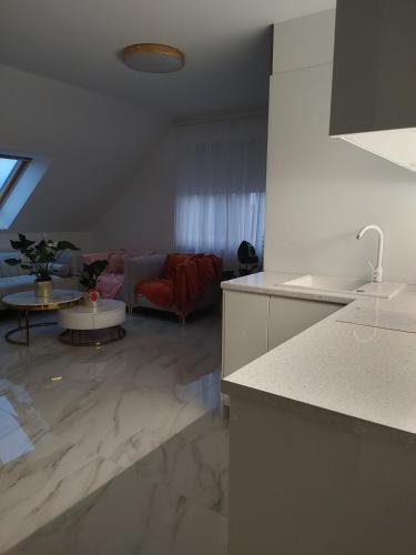 a kitchen and living room with a marble floor at Apartament Lipowa 2 in Mrągowo