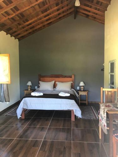 um quarto com uma cama e piso de madeira em Pousada Vale dos Sonhos em Cunha