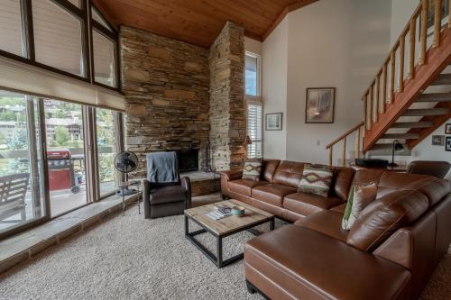 a living room with leather furniture and a stone fireplace at Powder Run 2 Bedroom and loft by Park City Vacations in Park City