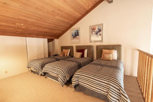 three beds in a room with wooden ceilings at Powder Run 2 Bedroom and loft by Park City Vacations in Park City