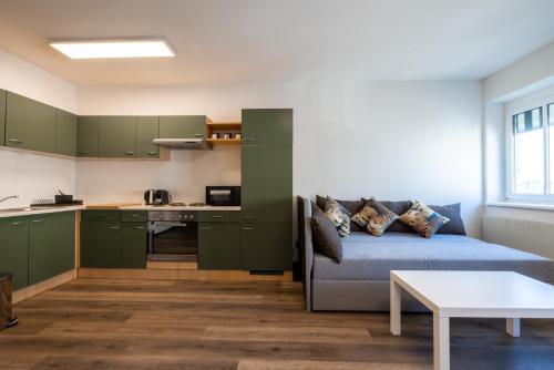 a living room with a couch and a kitchen at City Apartments Amstetten in Amstetten