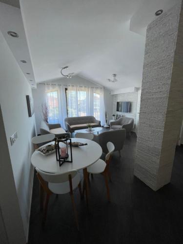 a room with tables and chairs and a living room at App 7 Aida in Umag