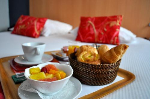a tray of food with pastries and fruit on a bed at Atalante in Annemasse