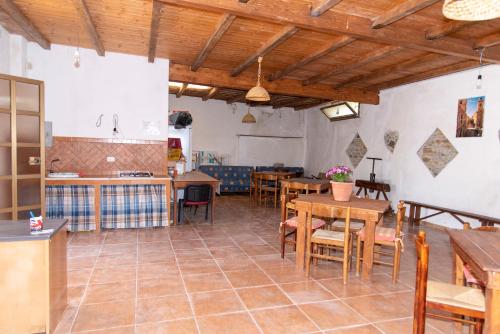 eine Küche und ein Esszimmer mit Holzdecken und Tischen in der Unterkunft Baglio Mustazza in Buseto Palizzolo